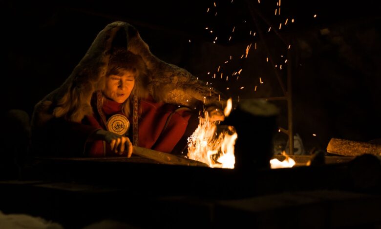 Warm campfire scene with a person in fur clothing enjoying a cozy night outdoors.