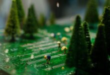 Creative scene of miniature figures farming on a circuit board with artificial trees.