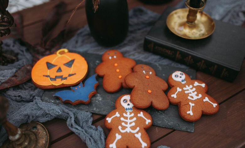 Halloween-themed cookies featuring skeletons and pumpkins on a spooky setup.