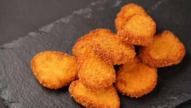 Delicious golden chicken nuggets stacked on a slate plate, ready to serve.