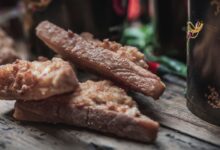 Delicious crispy fried chicken strips on rustic wooden table.