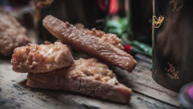 Delicious crispy fried chicken strips on rustic wooden table.