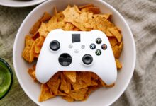 White Xbox controller resting on a bowl of nachos, perfect for gaming snack visuals.