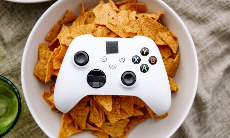 White Xbox controller resting on a bowl of nachos, perfect for gaming snack visuals.