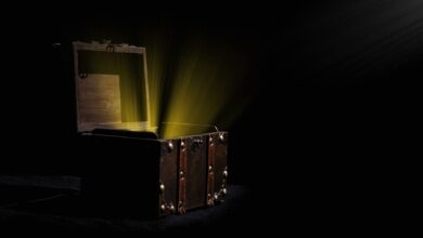 Open wooden chest emitting a mysterious glowing light in a dark room.