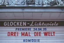 Retro cinema sign announcing 'Drei Mal Die Welt' premiere on April 24, 2020.