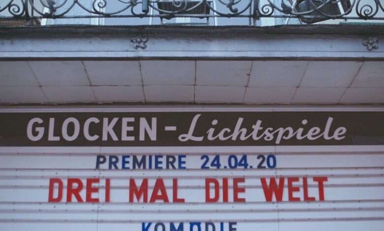 Retro cinema sign announcing 'Drei Mal Die Welt' premiere on April 24, 2020.