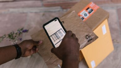 A person scans package barcodes using a smartphone for delivery logistics.