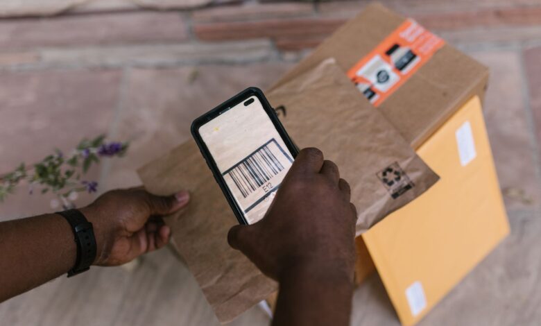 A person scans package barcodes using a smartphone for delivery logistics.