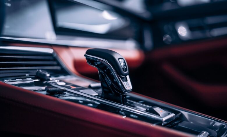 Close-up of a sleek automatic gear shift in a luxury car interior.