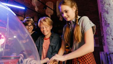 Group of teenagers having fun playing arcade games indoors.