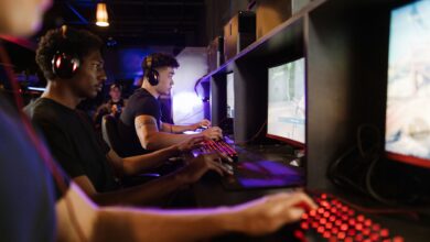 Young adults gaming at a modern LAN center with advanced PCs, showcasing intense gaming focus.