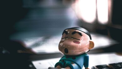 Close-up of a cartoon figurine sleeping on a table with soft lighting.