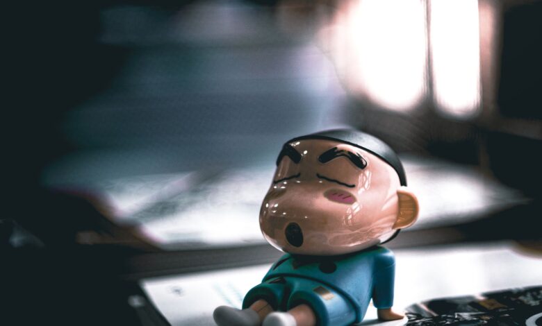 Close-up of a cartoon figurine sleeping on a table with soft lighting.