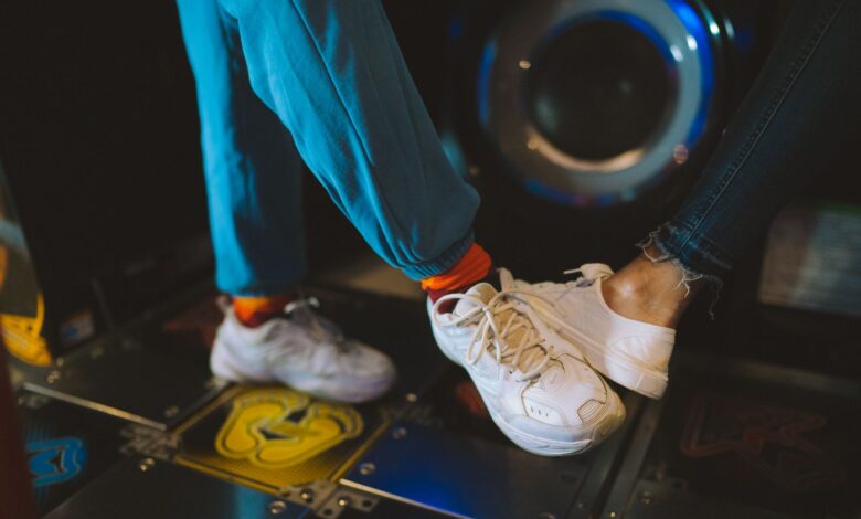 Dynamic close-up of feet playing an arcade dancing game, capturing movement and fun.