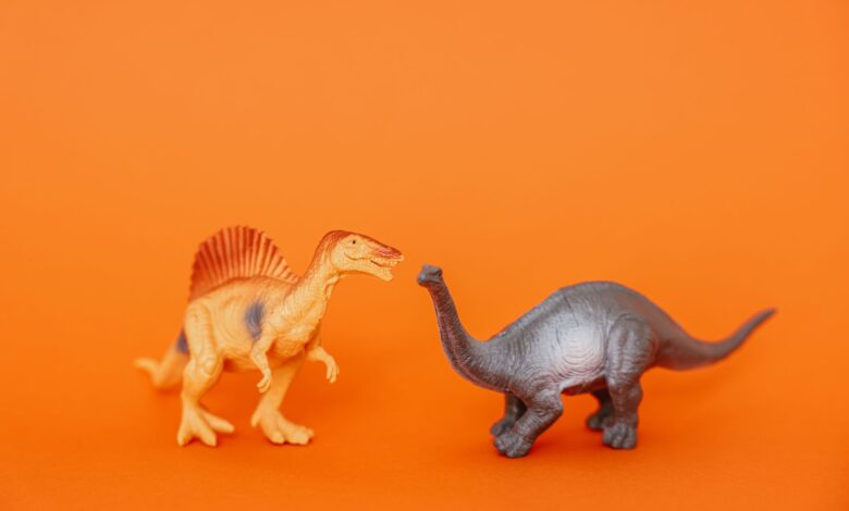 Miniature dinosaur toys in an orange setting showcasing prehistoric creatures.