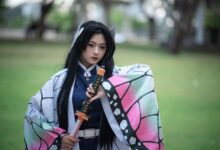 Cosplaying individual dressed as a character from anime, holding a sword in an outdoor setting.