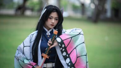 Cosplaying individual dressed as a character from anime, holding a sword in an outdoor setting.