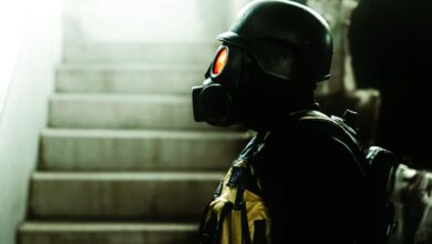 Dark indoor scene featuring a figure in gas mask and helmet, evoking horror and Halloween vibes.
