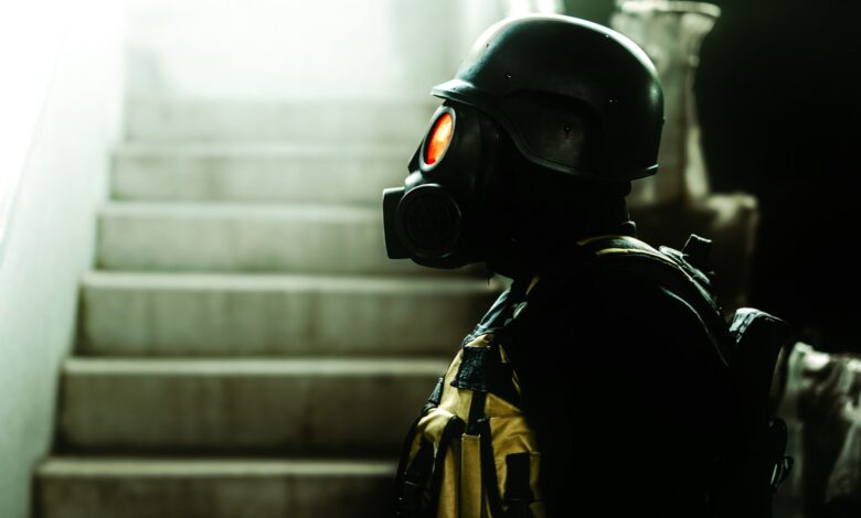 Dark indoor scene featuring a figure in gas mask and helmet, evoking horror and Halloween vibes.