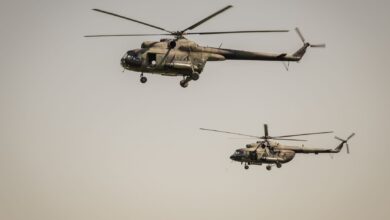 Two military helicopters flying over clear skies, showcasing aviation power.