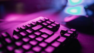 A close-up view of an RGB backlit gaming keyboard with a vibrant purple glow, perfect for tech and gaming enthusiasts.