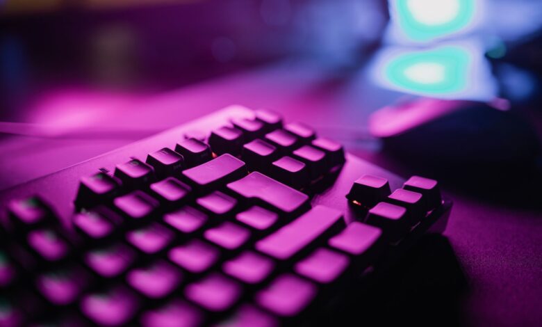 A close-up view of an RGB backlit gaming keyboard with a vibrant purple glow, perfect for tech and gaming enthusiasts.