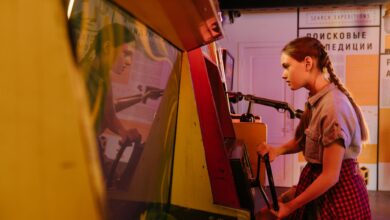 Teenage girl with pigtails playing a vintage arcade game indoors, reflecting vibrant 80s nostalgia.