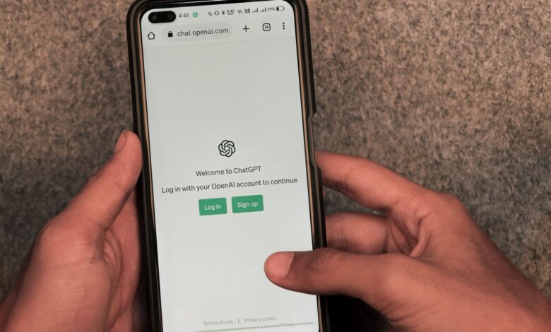 Close-up of hands using smartphone with ChatGPT app open on screen.