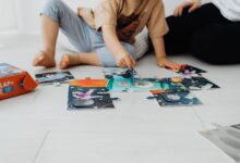 Two children assembling a colorful puzzle on the floor indoors.