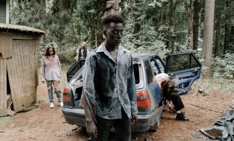 A chilling zombie scene unfolds by an abandoned car in a dense forest.