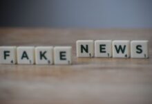 Scrabble tiles spelling 'Fake News' on a wooden surface highlighting misinformation.