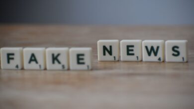 Scrabble tiles spelling 'Fake News' on a wooden surface highlighting misinformation.