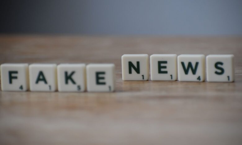 Scrabble tiles spelling 'Fake News' on a wooden surface highlighting misinformation.