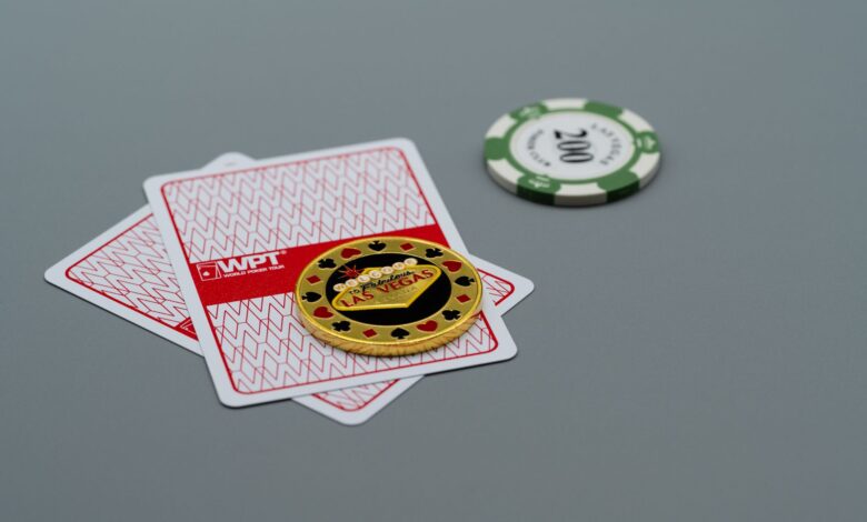 Two playing cards and poker chips, including a Las Vegas chip, on a grey background. Ideal for casino or gambling themes.
