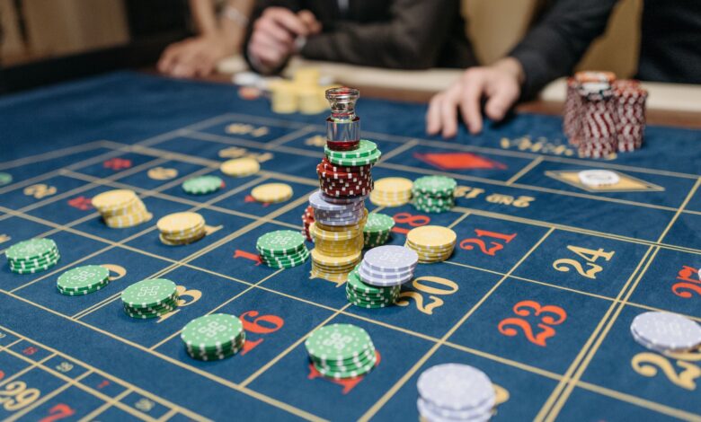 A casino table featuring stacked gaming chips and a roulette layout, suggesting gameplay.