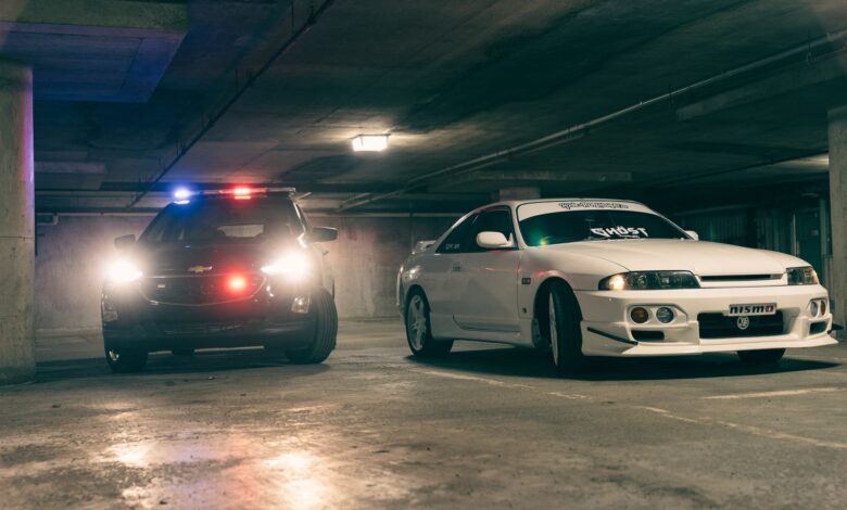 Police and sports cars in a dimly lit underground garage create a tense atmosphere.