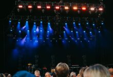 Night concert scene with audience, stage, and colorful lighting effects.