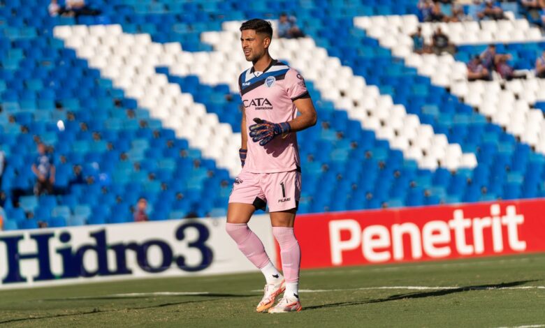 Goalkeeper wearing pink kit on the soccer field during a match.