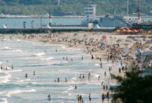 Crowded beach in Bulgaria with people enjoying a sunny day by the shore.