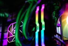 Close-up of colorful RGB illuminated PC components showcasing RAM and cooling system.