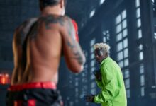 Two fighters engaged in cosplay-themed martial arts sparring inside a warehouse.