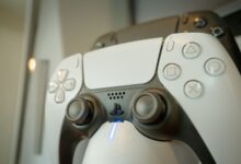 A detailed view of a gaming controller highlighting its buttons and LED light, perfect for gaming enthusiasts.