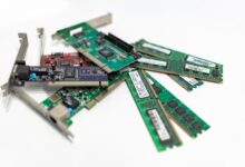 A detailed close-up of computer RAM sticks and PCI cards arranged on a white surface for tech illustration.