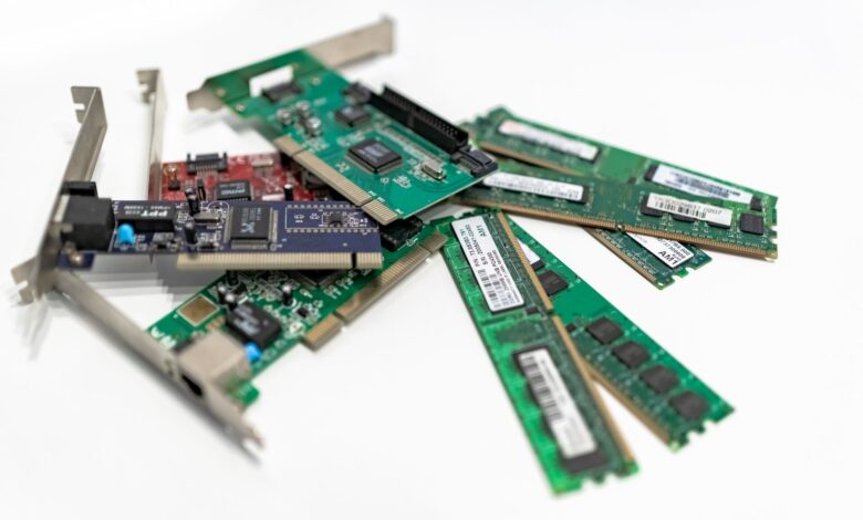 A detailed close-up of computer RAM sticks and PCI cards arranged on a white surface for tech illustration.