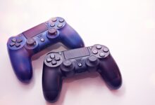 Close-up of two PlayStation controllers on a white surface, perfect for gaming themes.