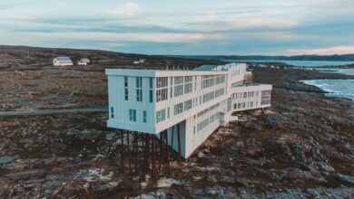 Aerial view of Fogo Island Inn on a rocky coast with ocean backdrop at dusk, Newfoundland.