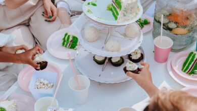 Adults and children enjoying a festive garden party with vibrant cakes and cupcakes.