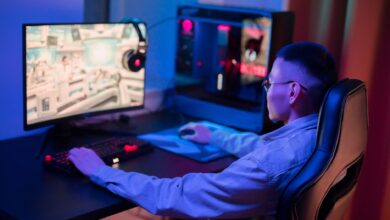 A young man intensely gaming on a computer at home, showcasing a modern gaming setup.