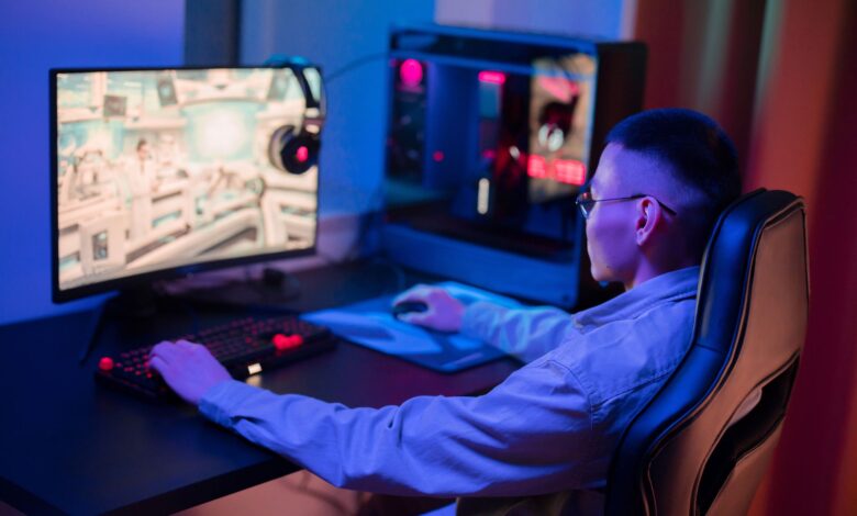 A young man intensely gaming on a computer at home, showcasing a modern gaming setup.